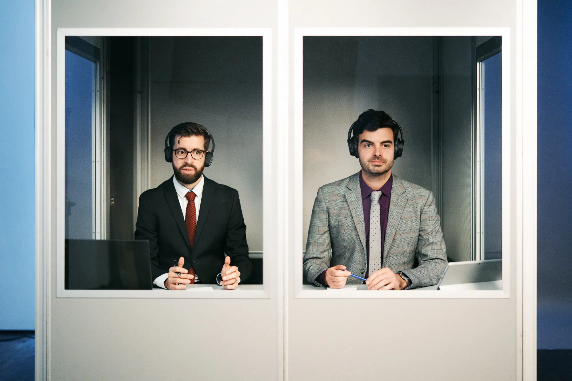 Jeremy Groves und Daniel Holt in einer Dolmetschkabine sitzend